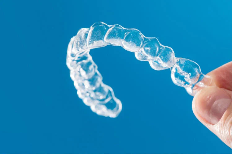 Primer plano de una persona sosteniendo un retenedor dental