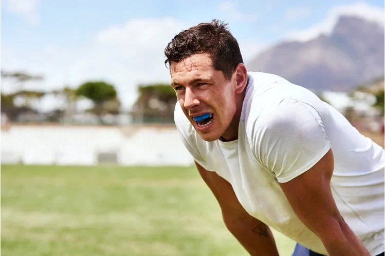 Un niño colocándose un protector bucal deportivo antes del juego.