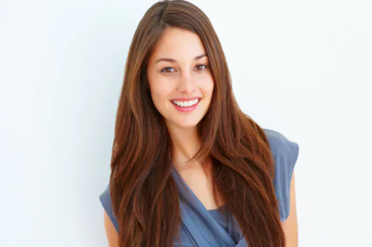 Una joven sonriendo para mostrar sus dientes rectos.