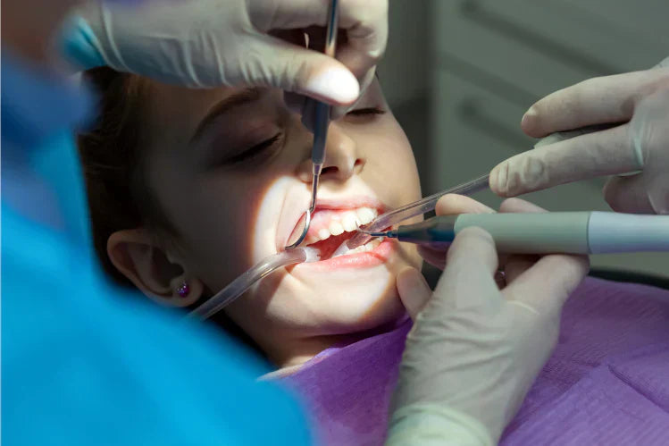 Una niña se somete a un procedimiento dental en el consultorio del dentista.