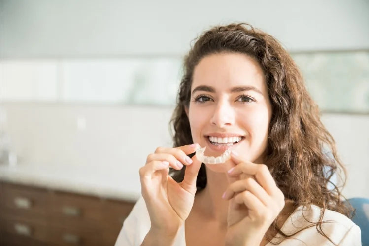 Mujer sosteniendo retenedores dentales